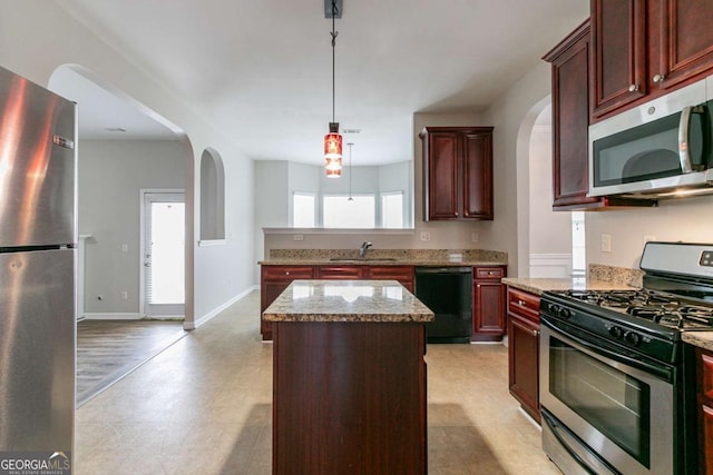 kitchen with a kitchen island, pendant lighting, sink, light stone counters, and stainless steel appliances