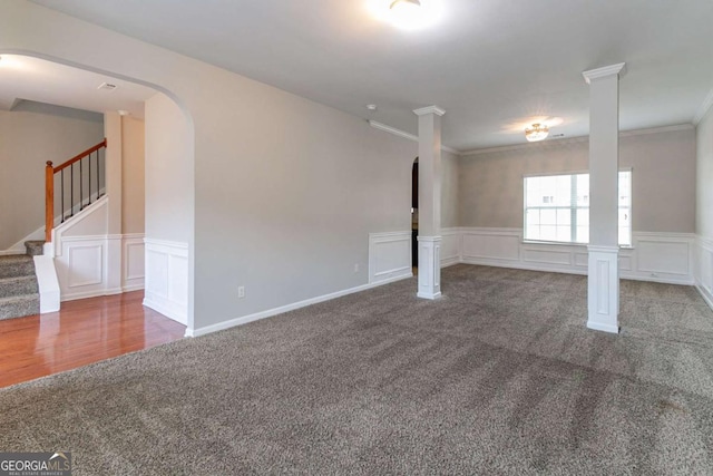 carpeted spare room featuring ornate columns and crown molding