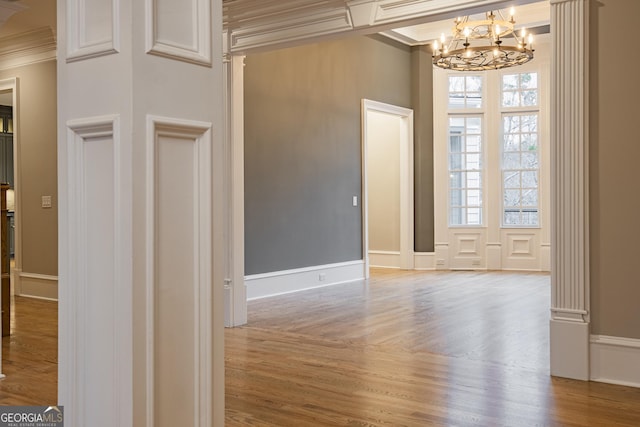 interior space featuring an inviting chandelier, hardwood / wood-style flooring, and ornamental molding