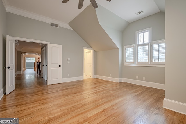 additional living space with ceiling fan, lofted ceiling, a healthy amount of sunlight, and light hardwood / wood-style flooring