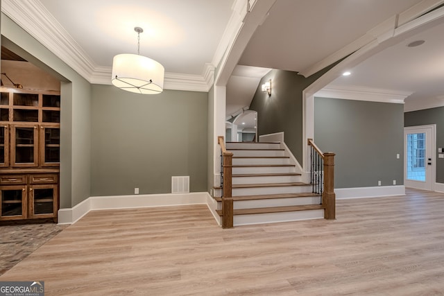 stairs with hardwood / wood-style flooring and crown molding