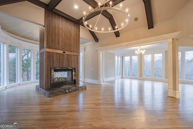 unfurnished living room featuring an inviting chandelier, beam ceiling, wood-type flooring, and a multi sided fireplace