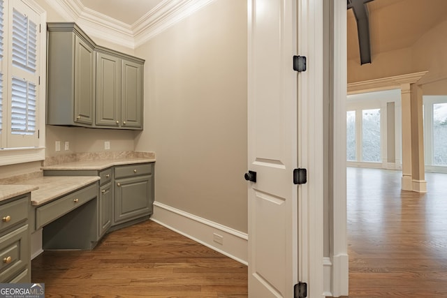 interior space with gray cabinetry, wood-type flooring, ornamental molding, and ornate columns