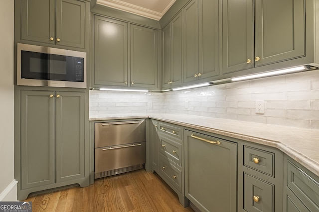 kitchen featuring built in microwave, wood-type flooring, and decorative backsplash