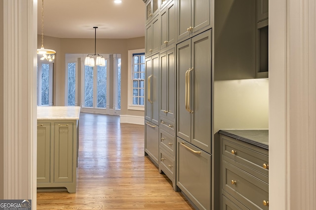 kitchen with gray cabinetry, pendant lighting, a notable chandelier, and light hardwood / wood-style floors