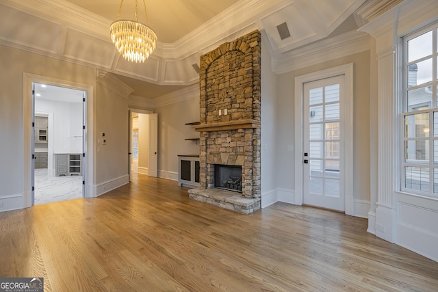 unfurnished living room featuring ornamental molding, a stone fireplace, and plenty of natural light