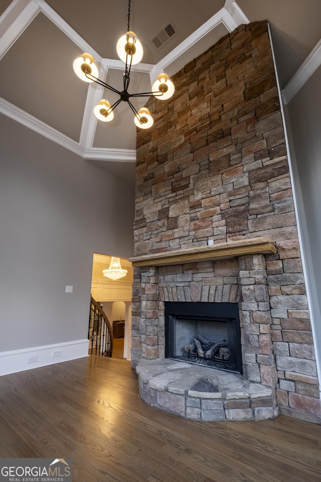 details featuring hardwood / wood-style flooring, a stone fireplace, a chandelier, and crown molding