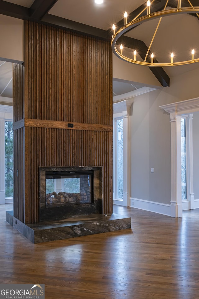 details with a multi sided fireplace, wood-type flooring, and beam ceiling