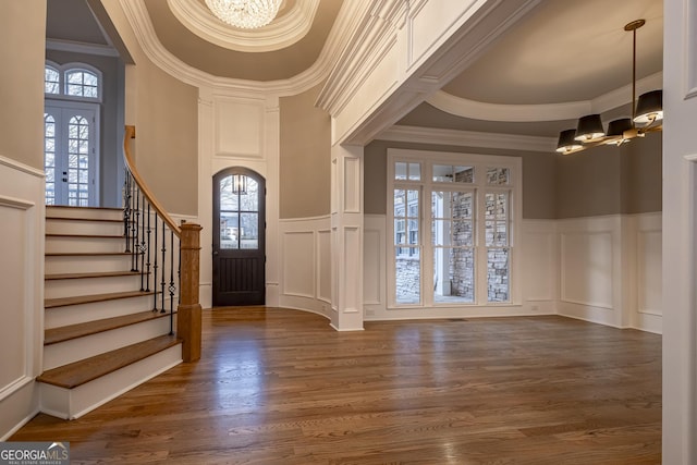 entrance foyer featuring crown molding, dark wood-type flooring, and an inviting chandelier