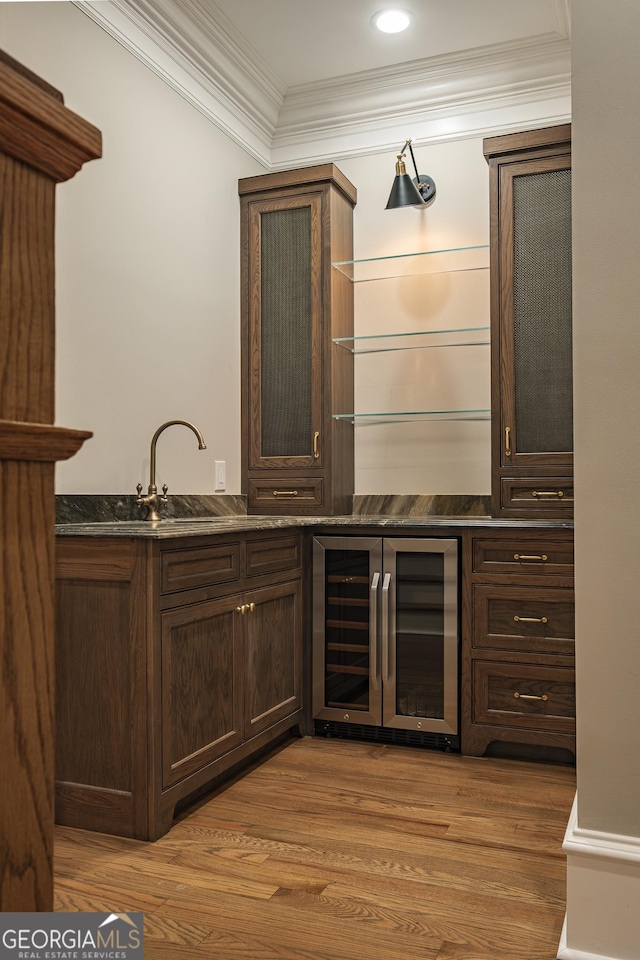 bar featuring crown molding, sink, wine cooler, and light hardwood / wood-style floors