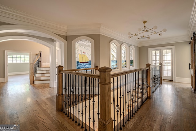 corridor featuring crown molding, hardwood / wood-style floors, and a chandelier