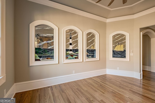 unfurnished room featuring wood-type flooring, ornamental molding, and ceiling fan