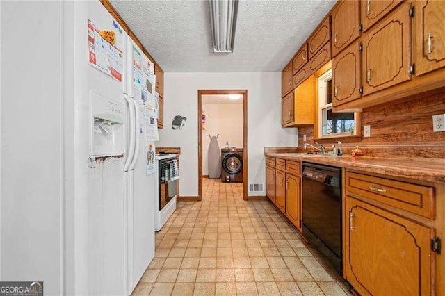 kitchen featuring sink, white appliances, washer / dryer, and a textured ceiling