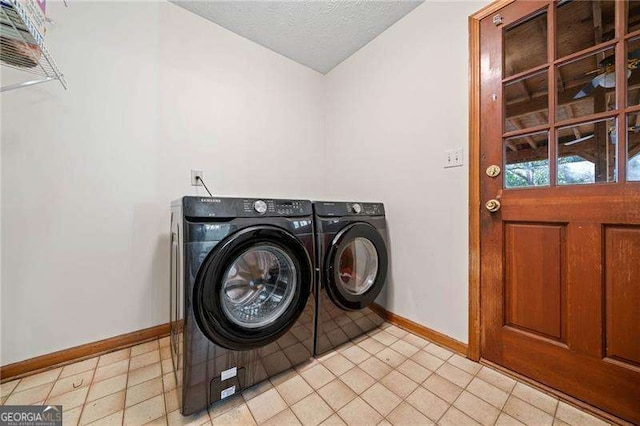 laundry area with washing machine and clothes dryer and a textured ceiling