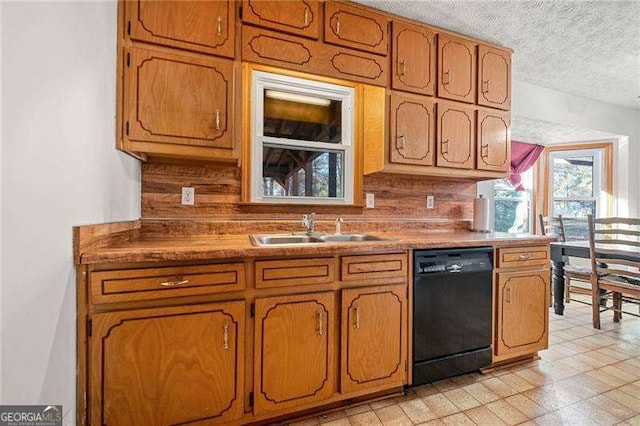 kitchen featuring tasteful backsplash, black dishwasher, sink, and a textured ceiling