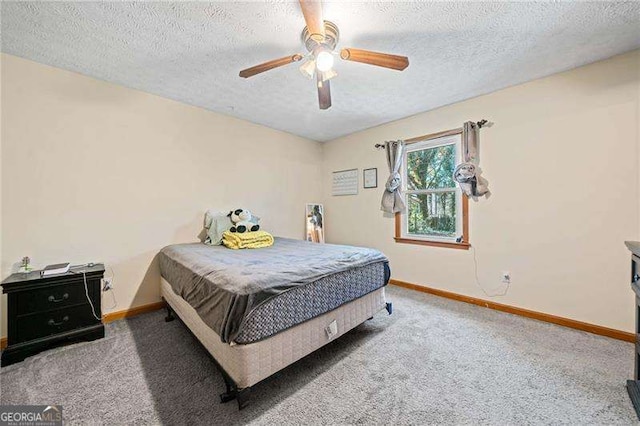 carpeted bedroom featuring ceiling fan and a textured ceiling