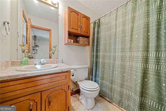 bathroom with vanity, tile patterned floors, a textured ceiling, and toilet