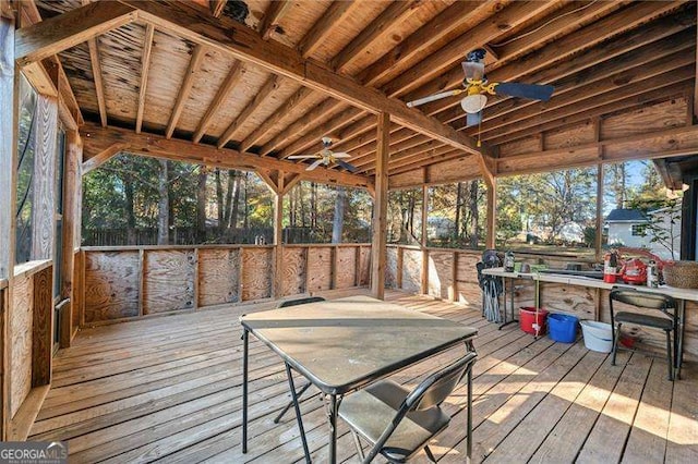 wooden deck featuring ceiling fan and a bar