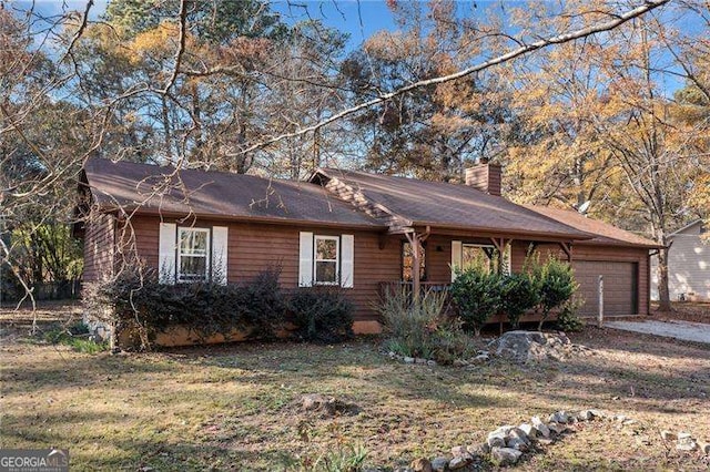 single story home featuring a garage and a front yard