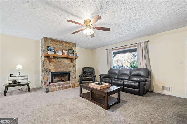 living room with a textured ceiling, a fireplace, ceiling fan, and carpet