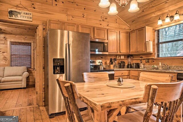 kitchen featuring wood ceiling, light hardwood / wood-style flooring, appliances with stainless steel finishes, vaulted ceiling, and wood walls