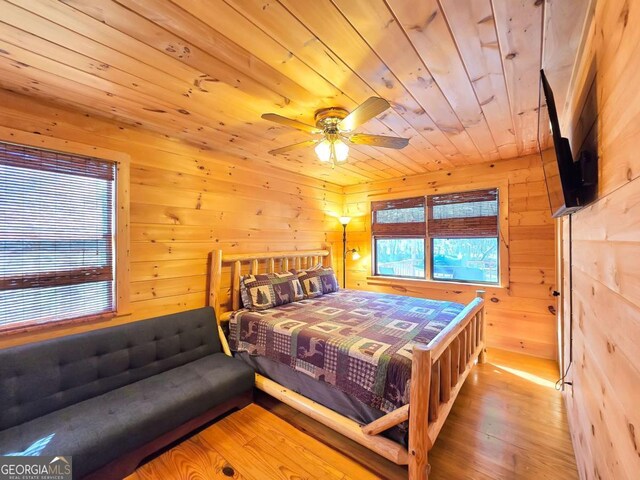 bedroom with wood ceiling, wood-type flooring, and wooden walls