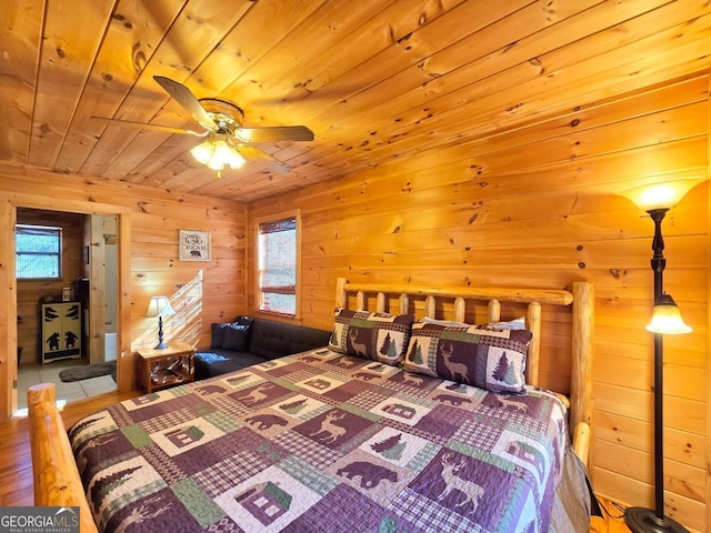 bedroom featuring wood ceiling, multiple windows, and wood walls