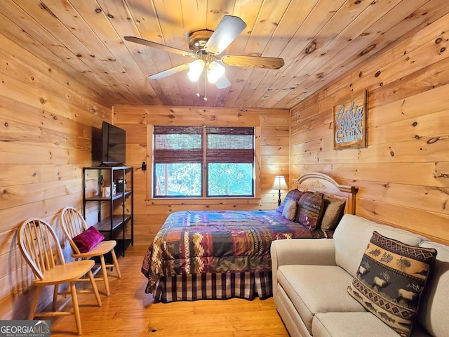 bedroom with wood walls, wooden ceiling, and light wood-type flooring