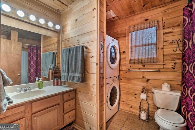 bathroom with tile patterned flooring, wood ceiling, wooden walls, and stacked washer and clothes dryer