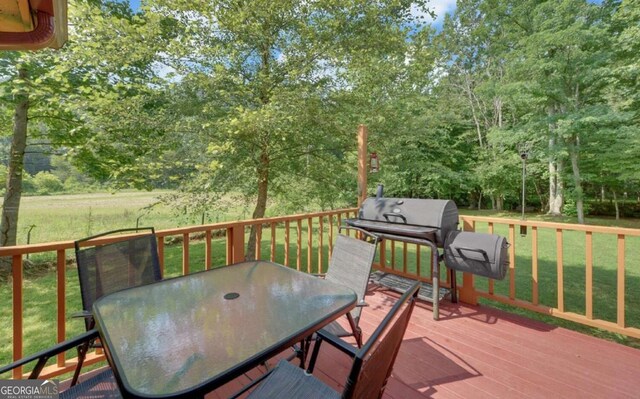 wooden terrace with a grill and a lawn