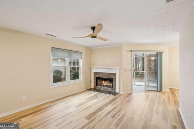 unfurnished living room with ceiling fan, a healthy amount of sunlight, and light hardwood / wood-style floors