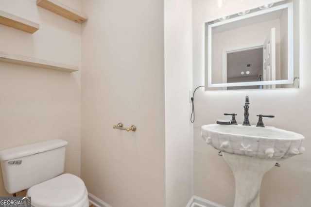 bathroom featuring baseboards and toilet