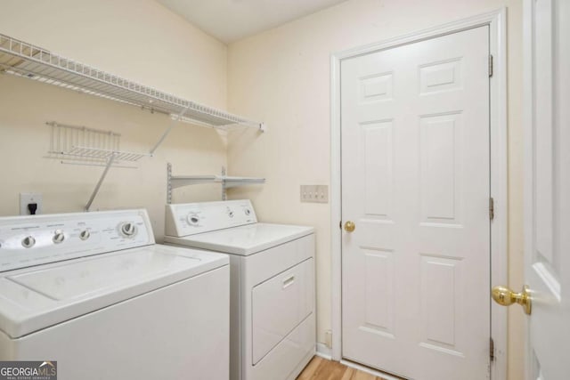 washroom with laundry area, light wood finished floors, and washer and dryer