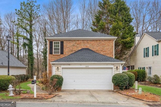 traditional-style home featuring concrete driveway, brick siding, roof with shingles, and an attached garage