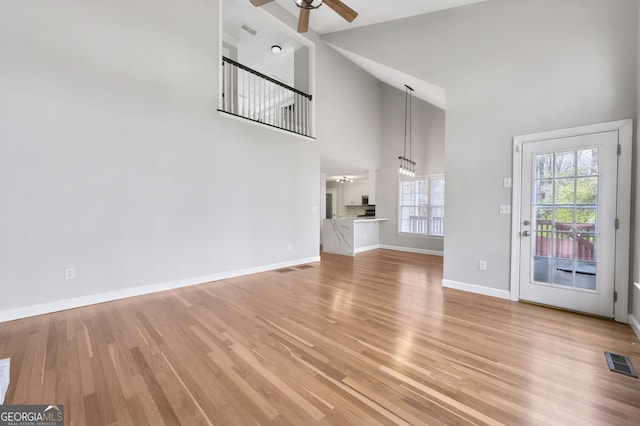 unfurnished living room featuring ceiling fan, high vaulted ceiling, and light hardwood / wood-style floors