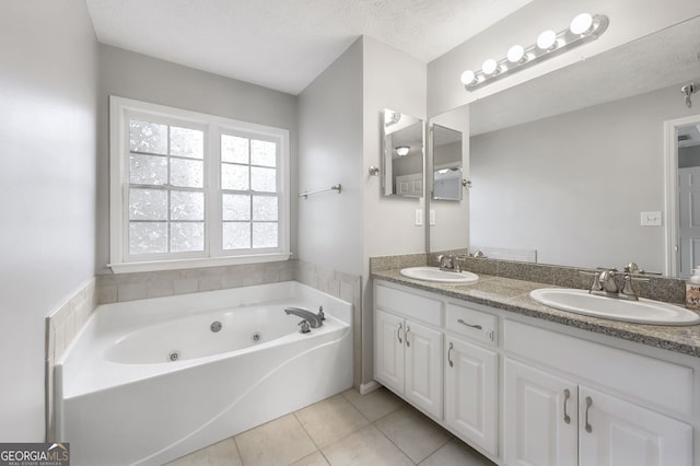 bathroom with tile patterned flooring, vanity, a bathtub, and a textured ceiling