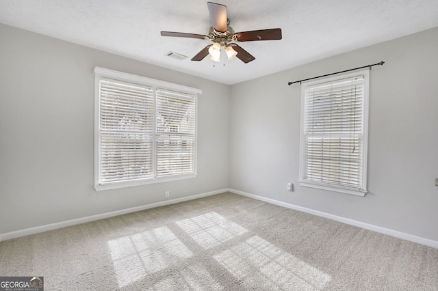 empty room featuring ceiling fan, a textured ceiling, and carpet flooring