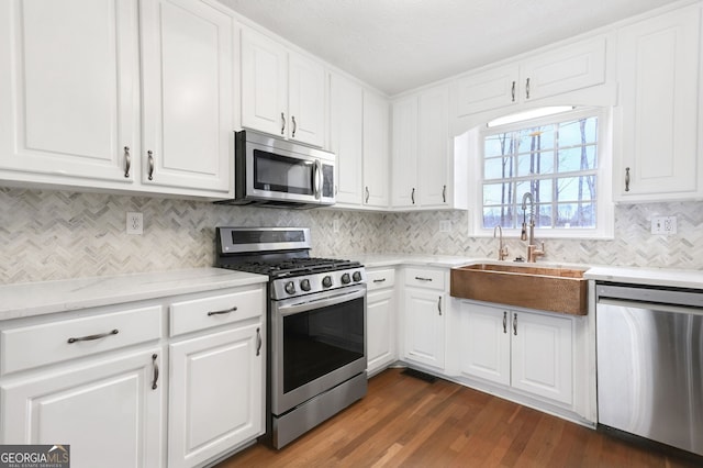 kitchen with sink, white cabinetry, dark hardwood / wood-style flooring, stainless steel appliances, and decorative backsplash