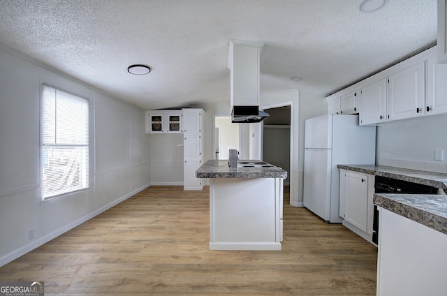 kitchen with white cabinetry, light hardwood / wood-style flooring, a center island, and white refrigerator