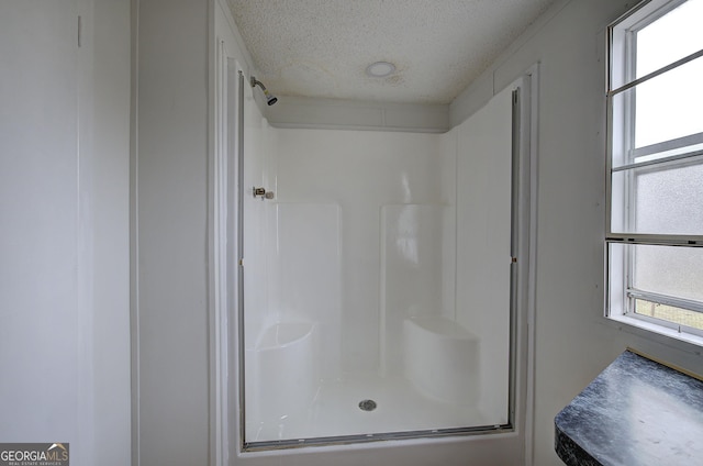 bathroom with a textured ceiling and walk in shower