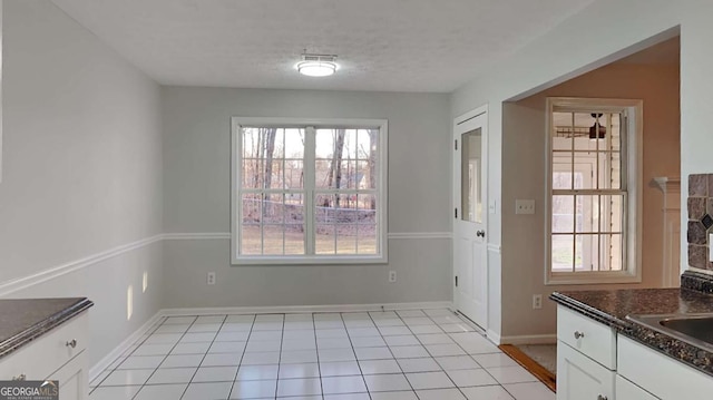 interior space featuring light tile patterned flooring, sink, and a textured ceiling