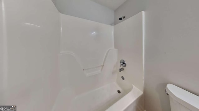 bathroom with toilet and  shower combination