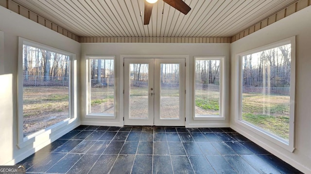 unfurnished sunroom with ceiling fan, a wealth of natural light, and wood ceiling