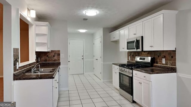 kitchen with white cabinetry, appliances with stainless steel finishes, light tile patterned flooring, and sink