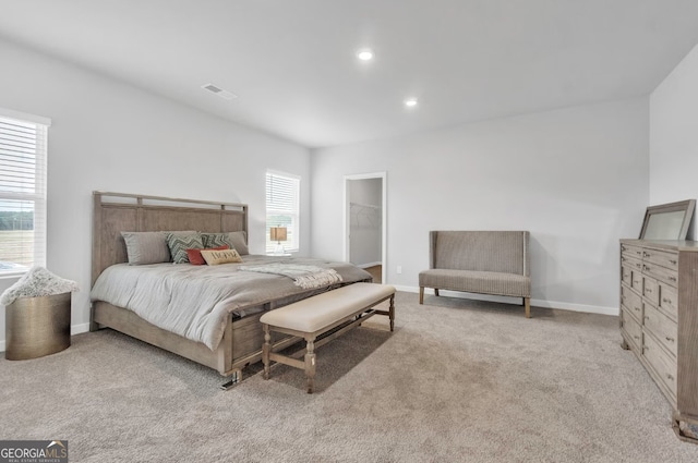 bedroom with recessed lighting, light colored carpet, visible vents, baseboards, and a spacious closet