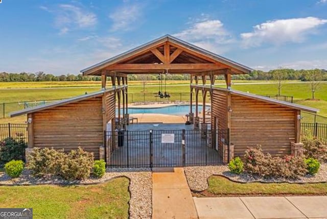 exterior space featuring a rural view, fence, a gazebo, a yard, and a swimming pool