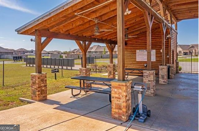 view of property's community featuring a residential view, a patio area, fence, and a lawn