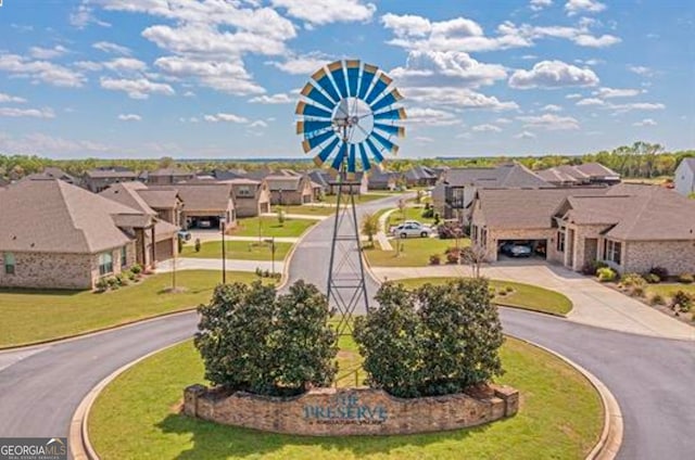 view of home's community featuring a yard, a residential view, and driveway