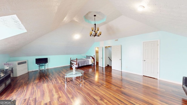 interior space with lofted ceiling, a notable chandelier, dark hardwood / wood-style floors, and a textured ceiling