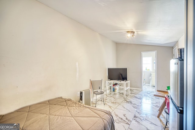 bedroom featuring radiator heating unit, vaulted ceiling, and stainless steel refrigerator